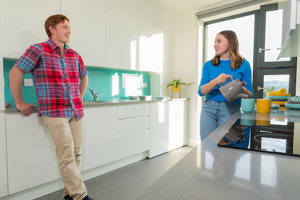 Two students standing and chatting in the kitchen of UCD accommodation